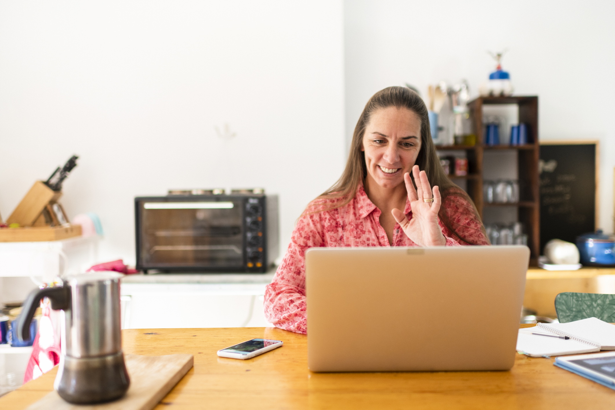 Woman greeting colleagues on video conference